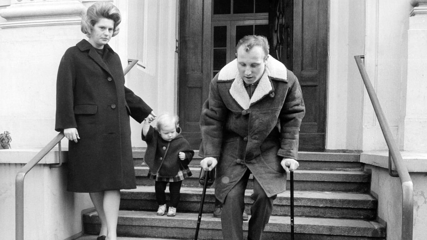 Uwe Seeler verlässt gemeinsam mit seiner Frau und seiner Tochter am 10.03.1965 auf Krücken das Krankenhaus.