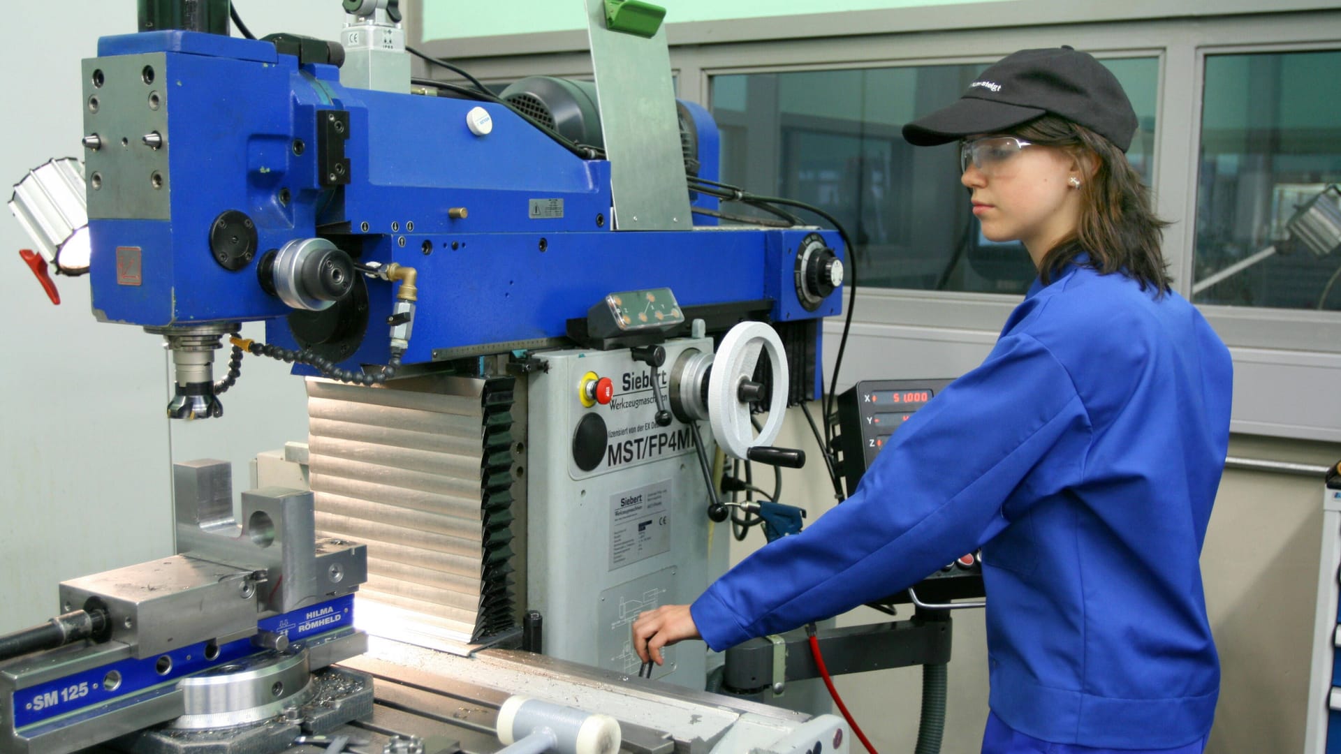 Eine Auszubildende steht an einer Fräsmaschine (Symbolbild): Der Fachkräftemangel könnte auf mittlere Sicht zu Wohlstandsverlusten in Deutschland führen. Eine Auszubildende steht an einer Fräsmaschine (Symbolbild): Der Fachkräftemangel könnte auf mittlere Sicht zu Wohlstandsverlusten in Deutschland führen.