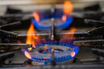 Eine blaue Gasflamme eines Gasherdes (Symbolbild): Die sogenannte Gasspeicherumlage soll die Kosten für den Gas-Einkauf ersetzen.