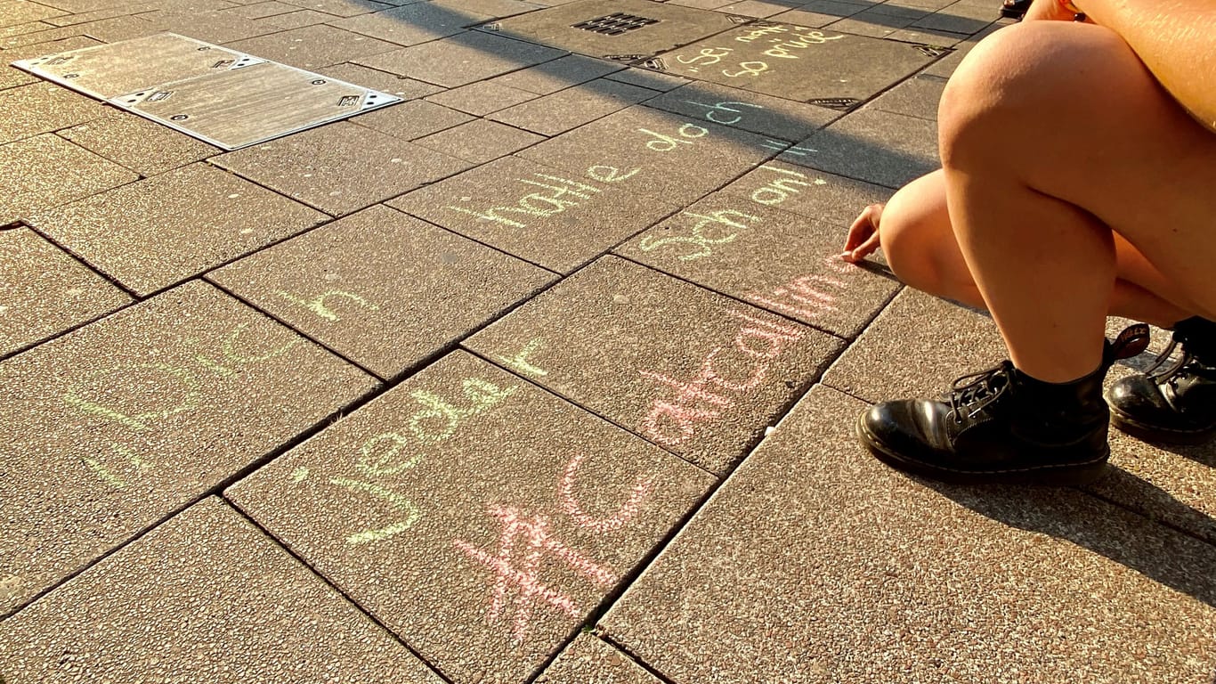 Eine Aktivistin schreibt einen sexualisierten Spruch mit Kreide auf den Boden: Die verschiedenen Catcalls wurden vorab in einer Aktion im Internet gesammelt.