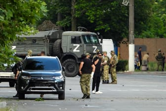 Russische Soldaten stehen auf der Straße in Melitopol (Archivbild): In der besetzten Stadt im Donbass soll es mehrere Explosionen gegeben haben.
