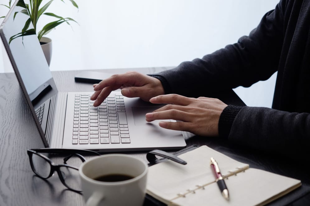Ein Mann arbeitet am Laptop (Symbolbild): Wer einem Nebenjob nachgeht, muss den Lohn mitunter nach Steuerklasse 6 versteuern.