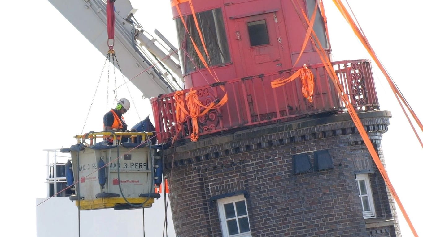 Ein Arbeiter an der Kuppel des schiefen Leuchtturms auf der Mole in Bremerhaven.