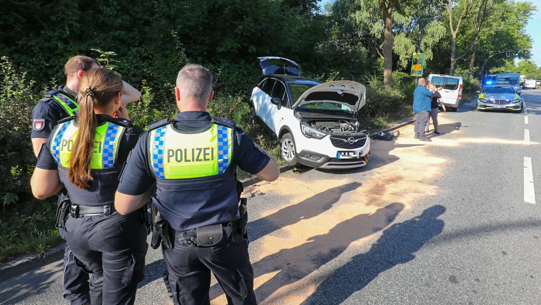 Polizisten beobachten die Unfallstelle in Hamburg: Vier Personen sollen verletzt sein. Polizisten beobachten die Unfallstelle in Hamburg: Vier Personen sollen verletzt sein.
