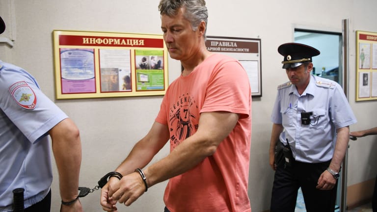 Jewgeni Roisman wird von Polizisten abgeführt: Der Kremlkritiker ist wieder auf freiem Fuß – mit Auflagen.