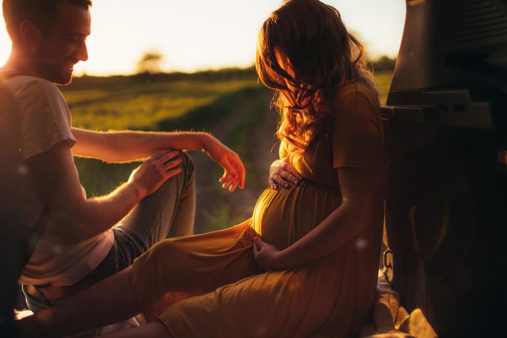 Pärchen im Sonnenuntergang: Schwangere können mit ihrem Partner im Babymoon noch einmal die Zeit zu zweit genießen. Oder Sie gönnen sich zusammen mit einer Freundin eine Auszeit.