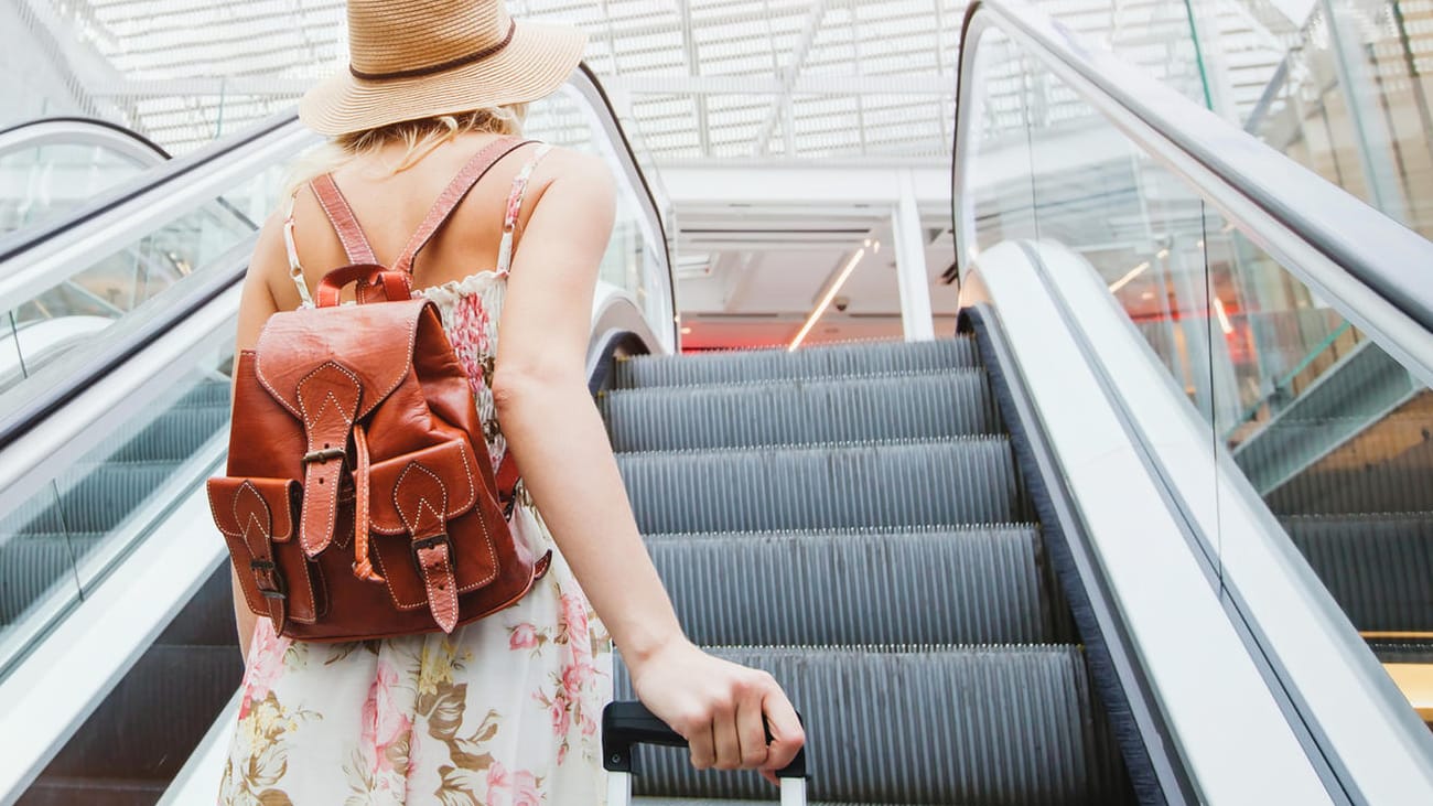 passenger in Frau fliegt in den Sommerurlaub: Wie gut sind Ihre Englischkenntnisse für die nächste Reise?airport, woman traveling with backpack