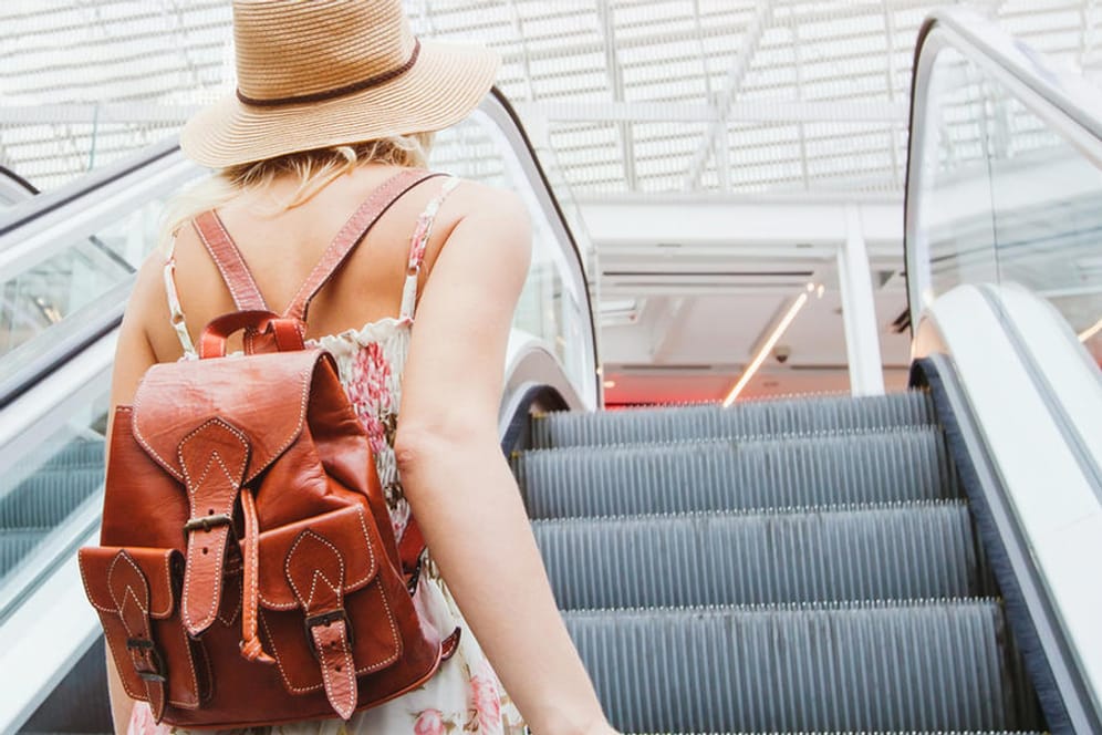 passenger in Frau fliegt in den Sommerurlaub: Wie gut sind Ihre Englischkenntnisse für die nächste Reise?airport, woman traveling with backpack