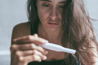 Frau betrachtet Schwangerschaftstest