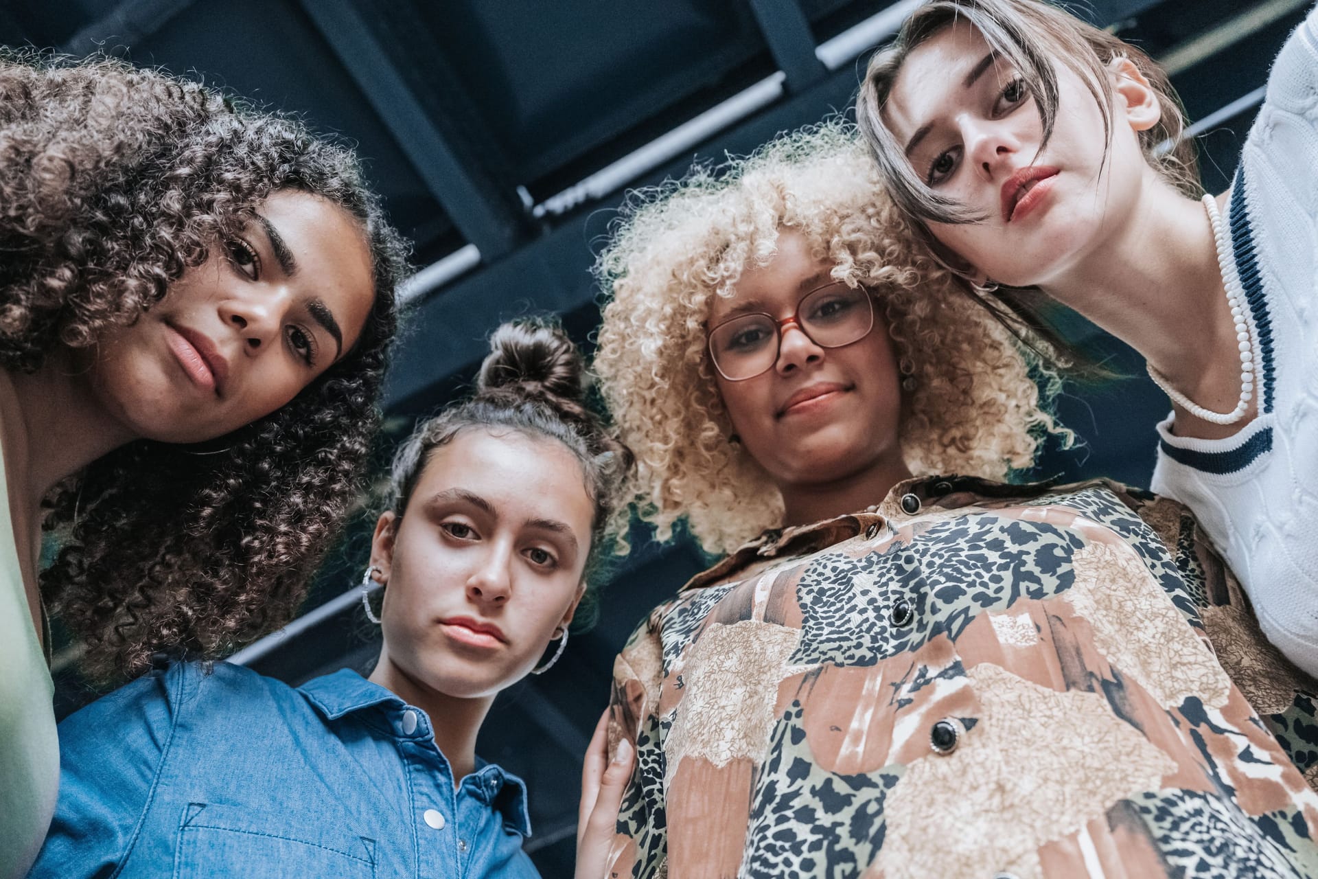 low angle view on four young woman standing in Berlin on street and looking at camera