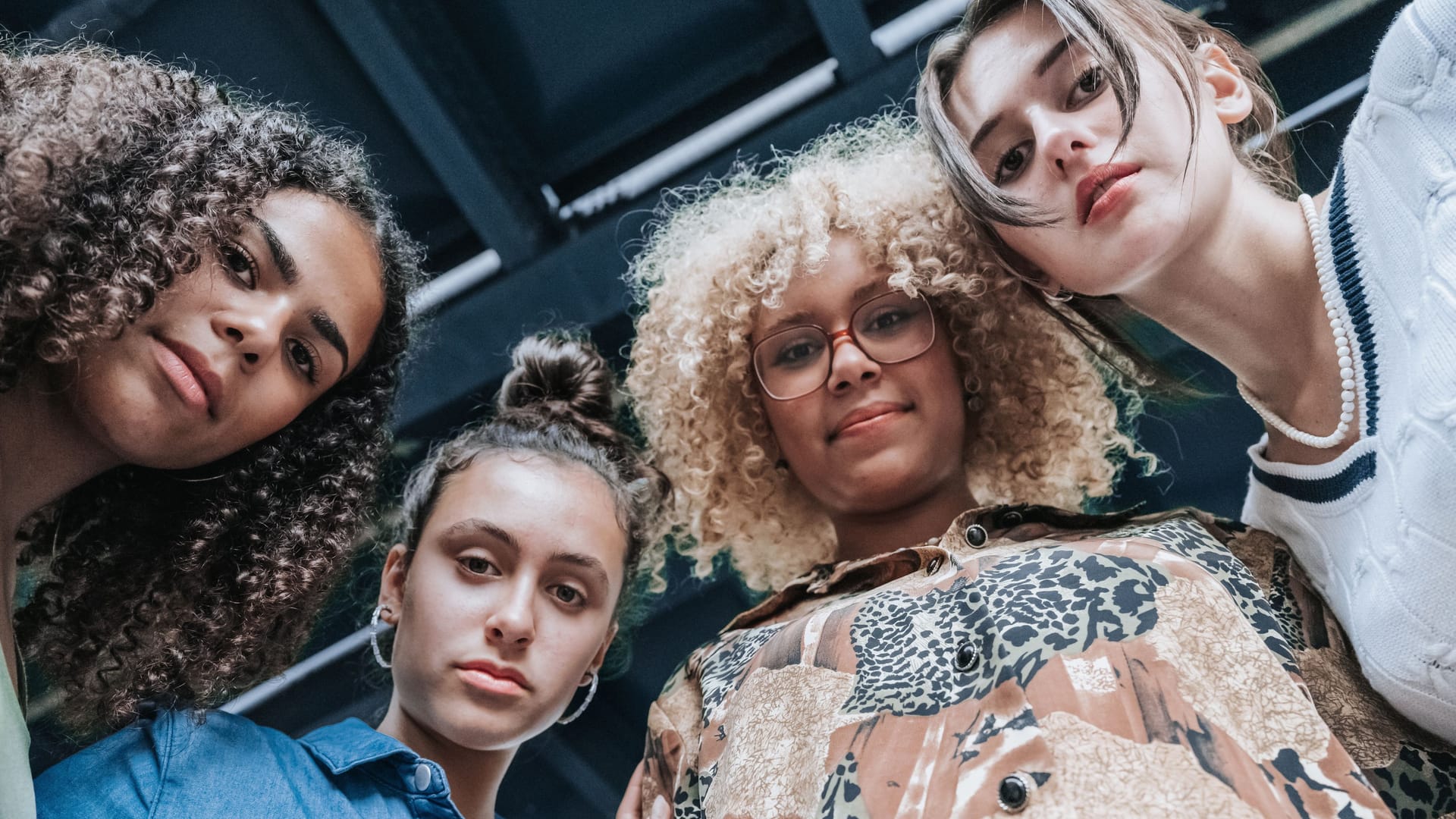 low angle view on four young woman standing in Berlin on street and looking at camera