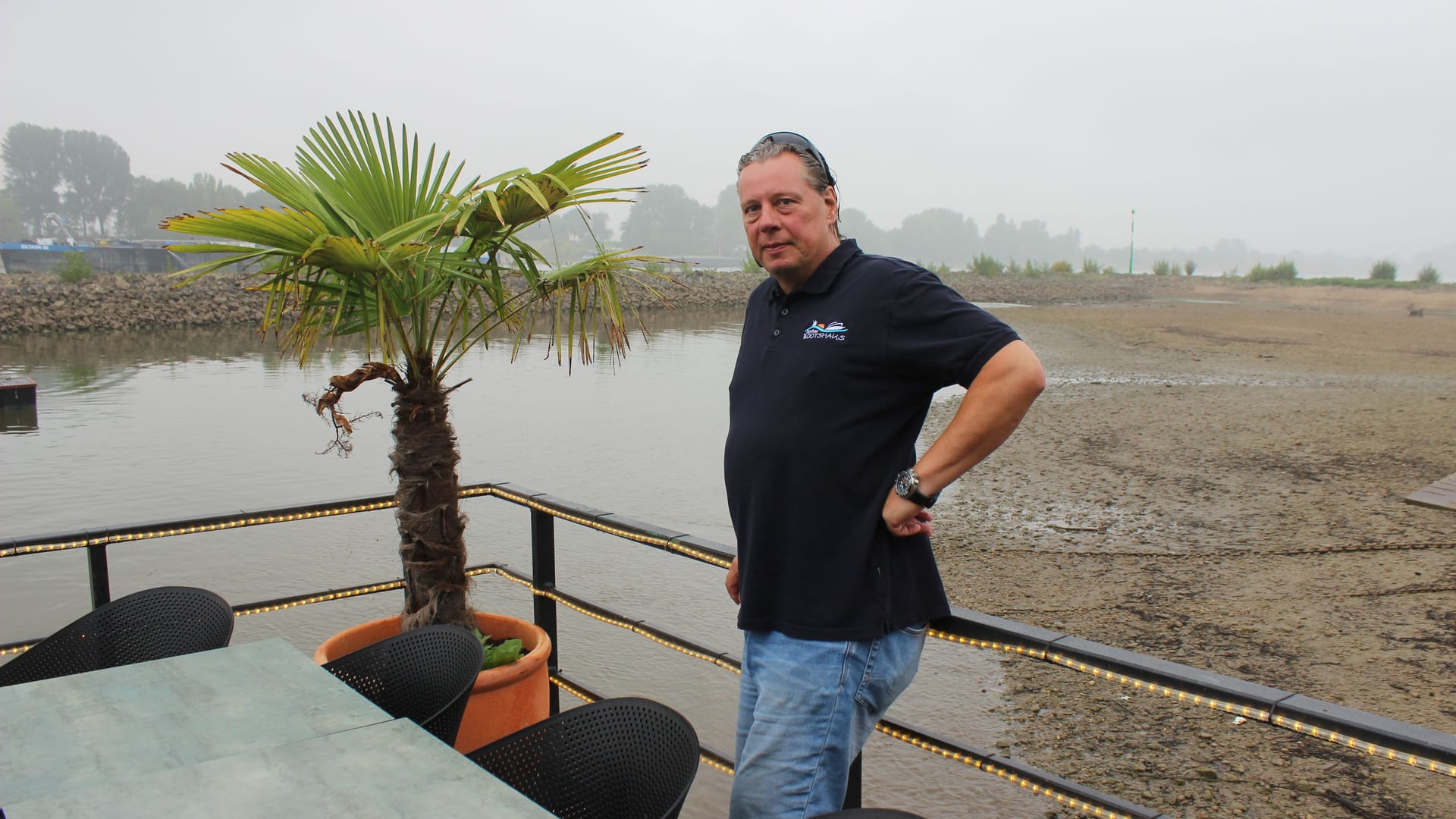 Jörg Blöck auf der Außenterrasse seines "Sürther Bootshauses": Der niedrige Wasserstand des Rheins hat das Restaurant auf Grund laufen lassen.