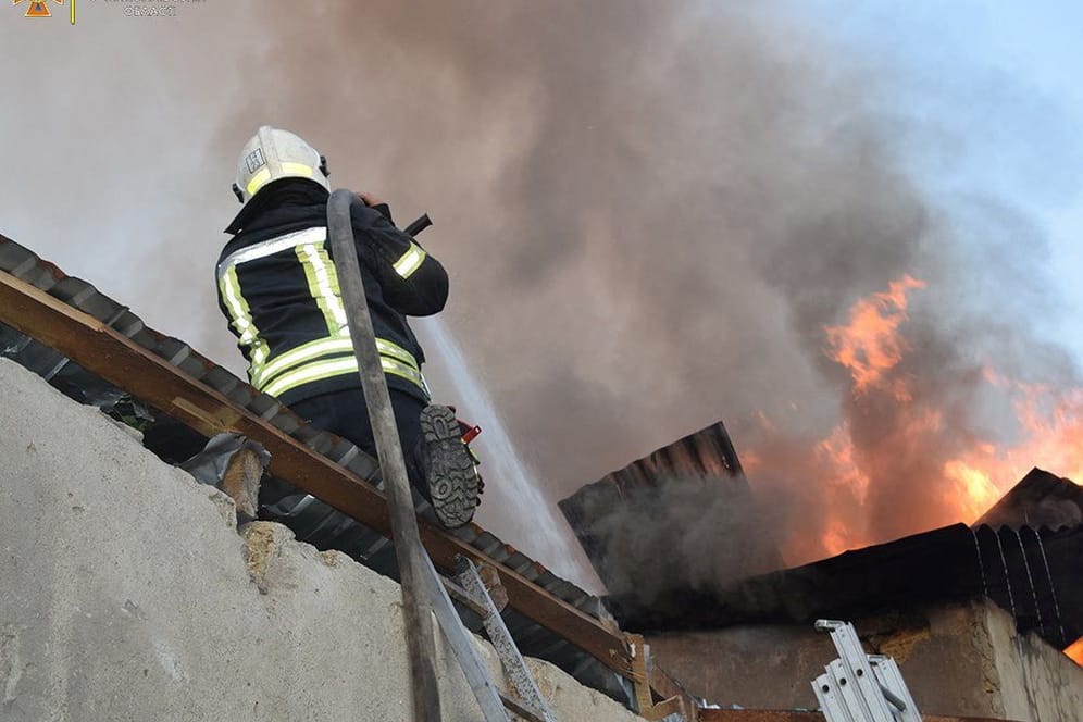 Ein Feuerwehrmann löscht einen Brand nach einem Raketenangriff in Mykolajiw: Auch in der Nacht wurde von Explosionen berichtet.