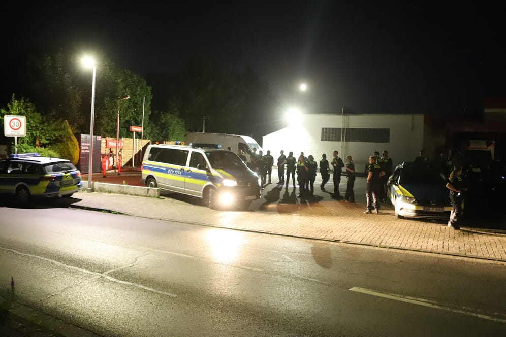 Mehrere Polizeibeamte stehen mit Einsatzfahrzeugen auf einem Parkplatz: Auch in Achim bei Bremen kam es am Montag zu einem größeren Polizeieinsatz.