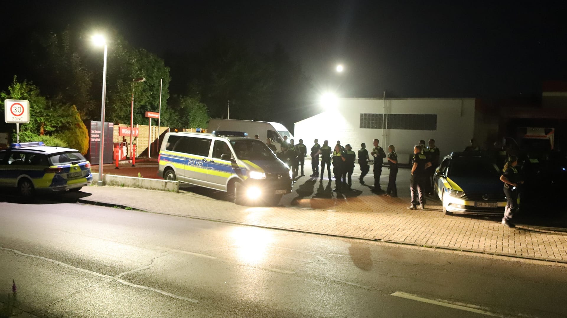 Mehrere Polizeibeamte stehen mit Einsatzfahrzeugen auf einem Parkplatz: Auch in Achim bei Bremen kam es am Montag zu einem größeren Polizeieinsatz.