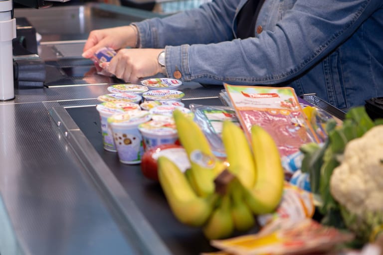 Eine Mitarbeiterin zieht einen Artikel über den Scanner (Symbolbild): An der Supermarktkasse ist die Inflation besonders spürbar.