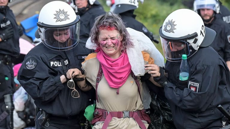 Klimaaktivistin wird abgeführt: Bei den Protesten in Hamburg gerieten Polizei und Demonstranten aneinander.