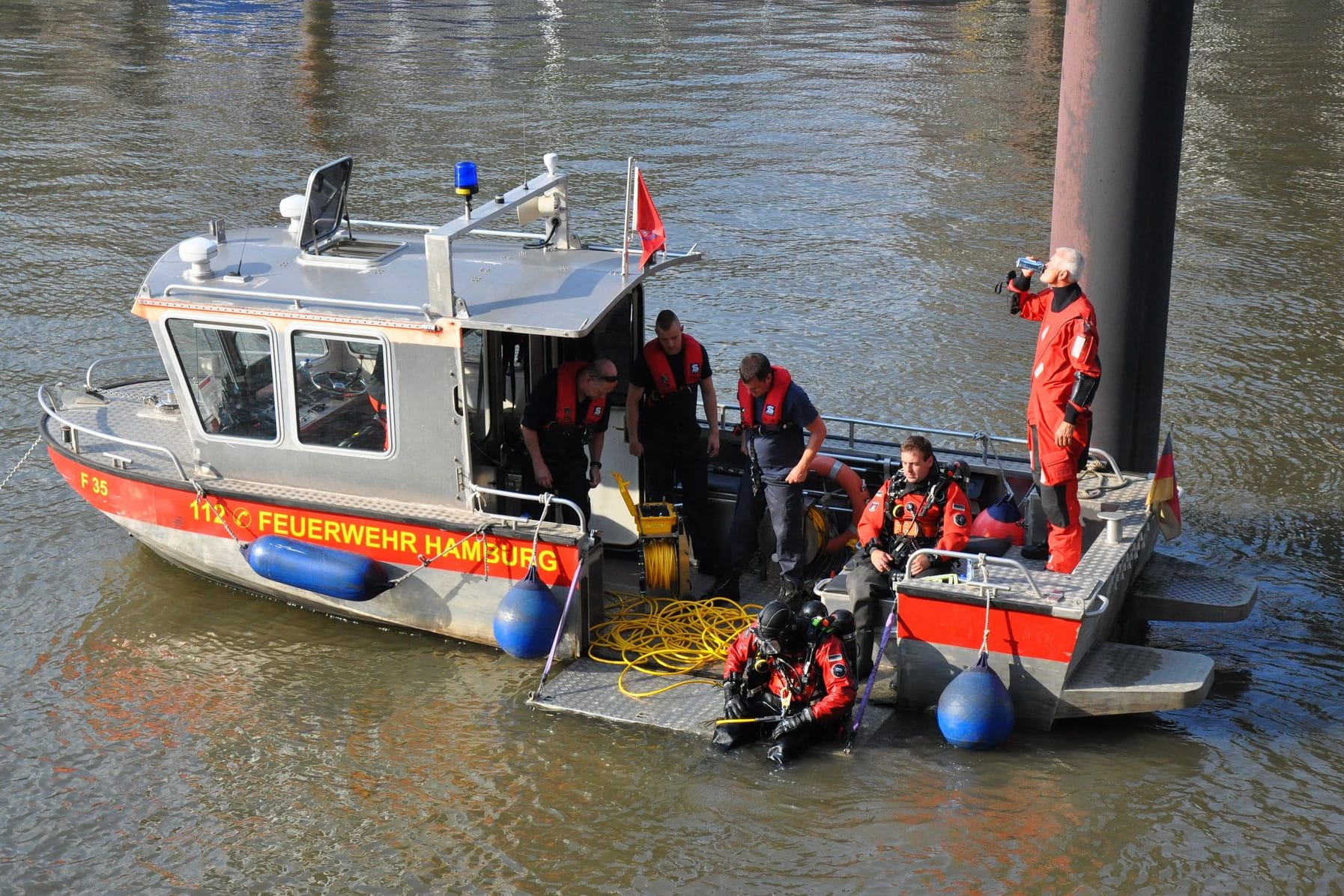 Taucher steigen ins Wasser der Elbe, um nach der Person zu suchen.