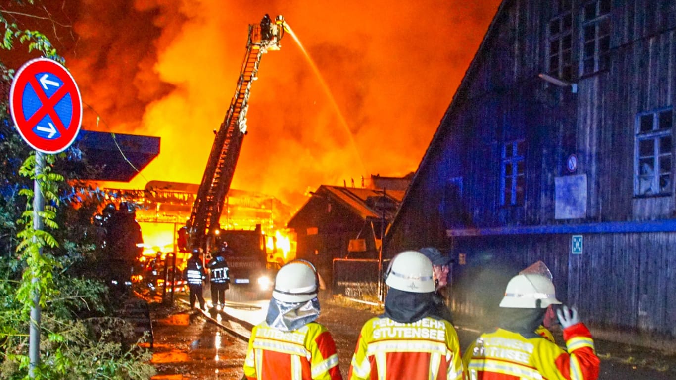 Baden-Württemberg, Weingarten: Einsatzkräfte der Feuerwehr löschen die brennende Lagerhalle.