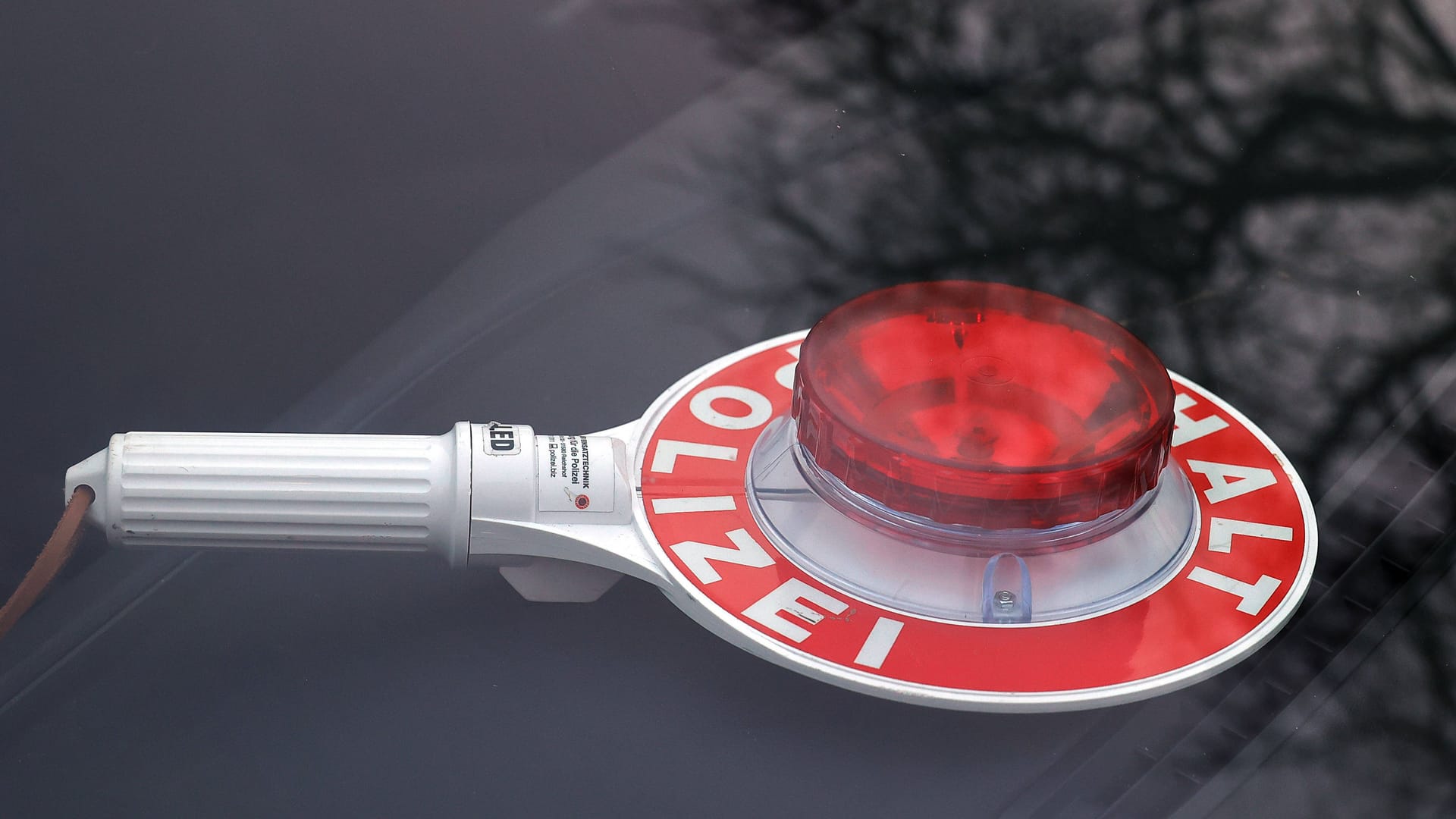 Polizeikelle in einem Auto (Symbolfoto): Die Beamten suchen den flüchtigen Fahrer.