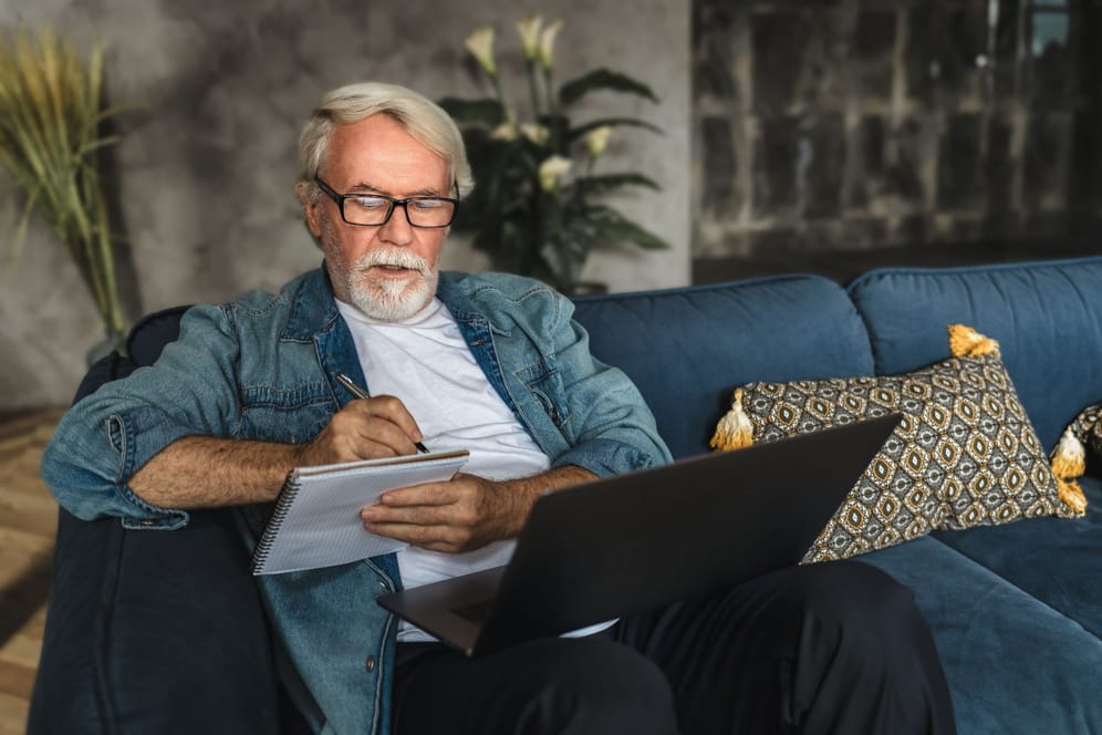 Älterer Mann am Laptop (Symbolbild): Wer wissen will, wann sein regulärer Rentenbeginn ist, kann einfach einen Online-Rechner befragen.