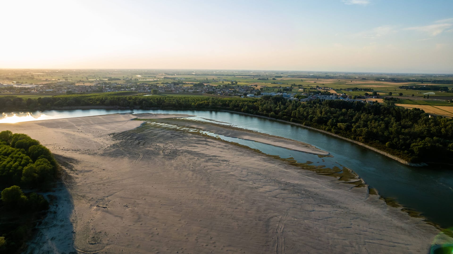 An dieser Flussbiegung bei Bergantino ist der Po normalerweise viermal so breit wie im Moment. An der nahegelegenen Messstation in Pontelagoscuro, kurz bevor der Fluss ins Mittelmeer mündet, plätschern nur noch 114 Kubikmeter pro Sekunde vorbei. Das entspricht weniger als einem Zehntel der Wassermenge, die hier im Hochsommer normal wären.