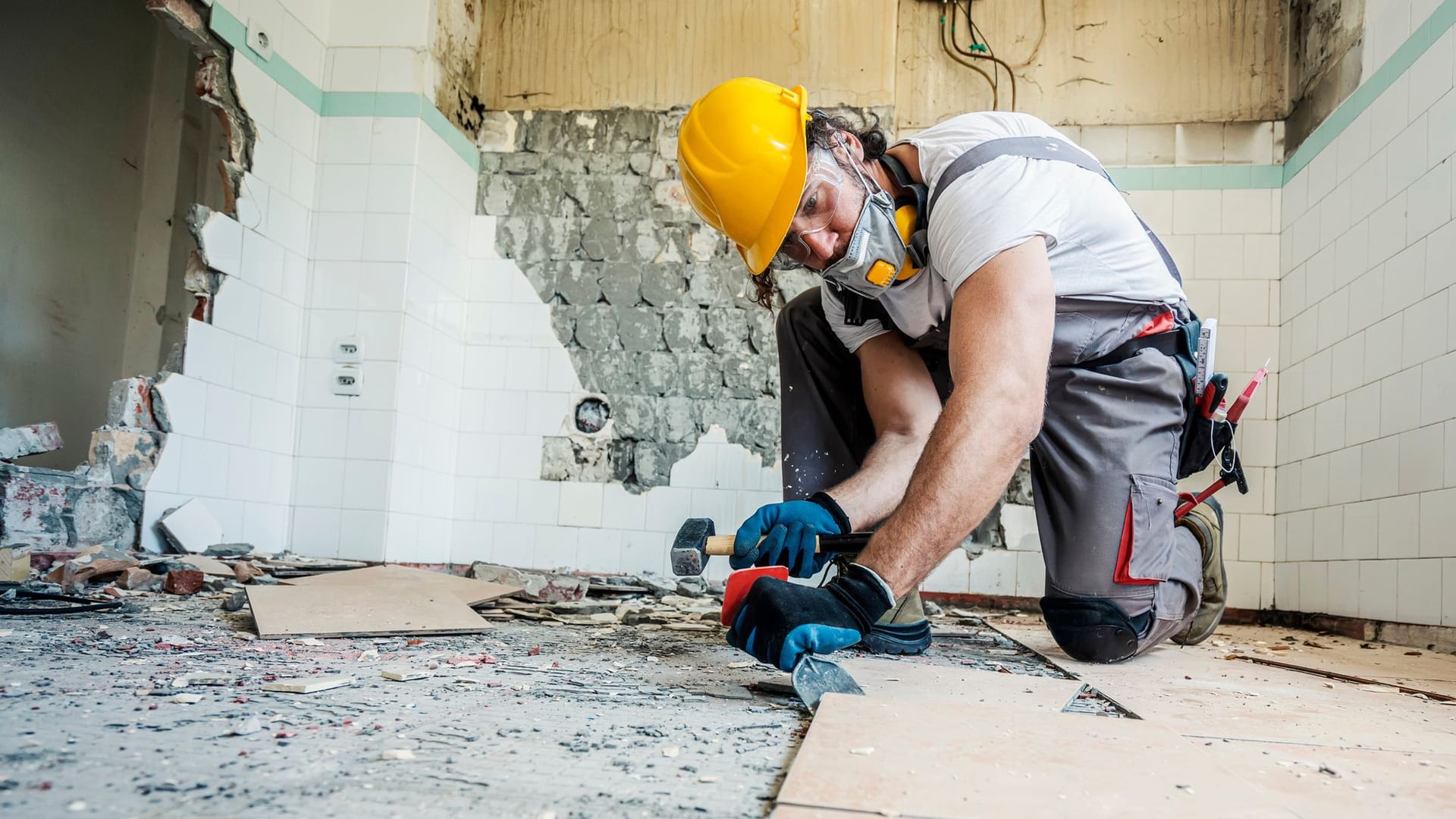 Handwerker erneuert den Boden (Symbolbild): An Handwerkerkosten können Sie das Finanzamt beteiligen.