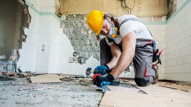 Handwerker erneuert den Boden (Symbolbild): An Handwerkerkosten können Sie das Finanzamt beteiligen.