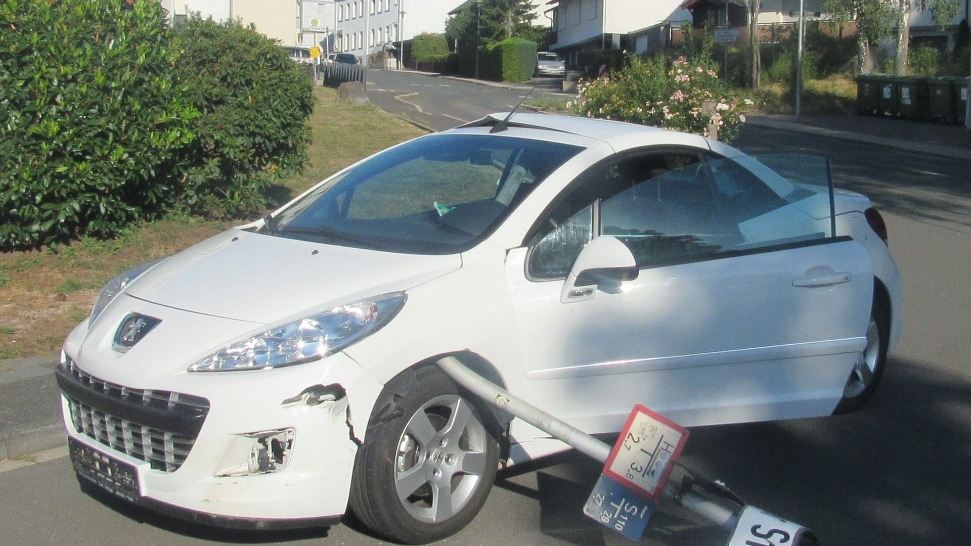 Auto mit Straßenschild: Die Polizei sucht Zeugen.