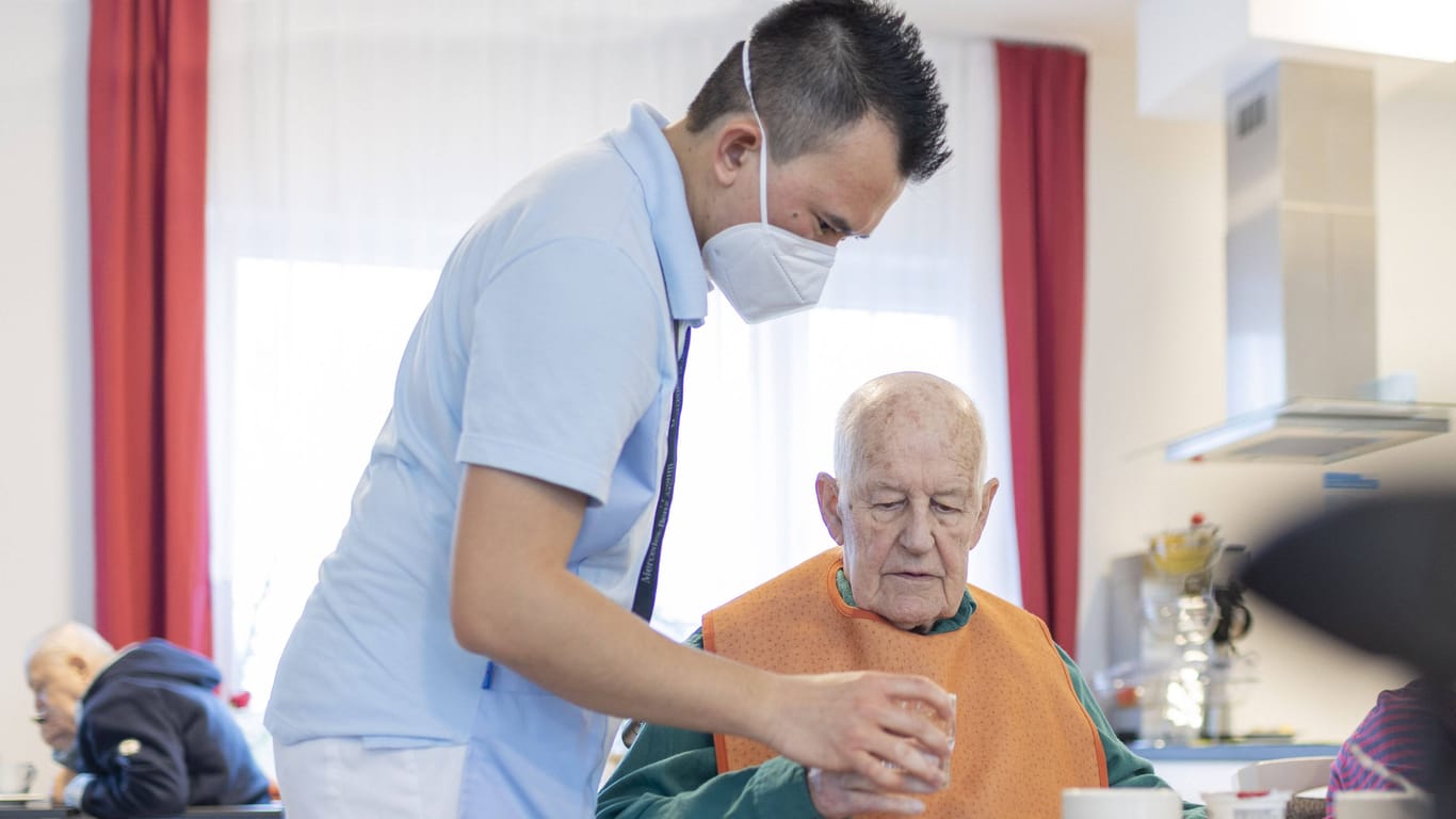 Pfleger hilft Mann beim Trinken (Symbolbild): Lauterbach ignoriere die Altenpflege, kritisieren die Patientenschützer.