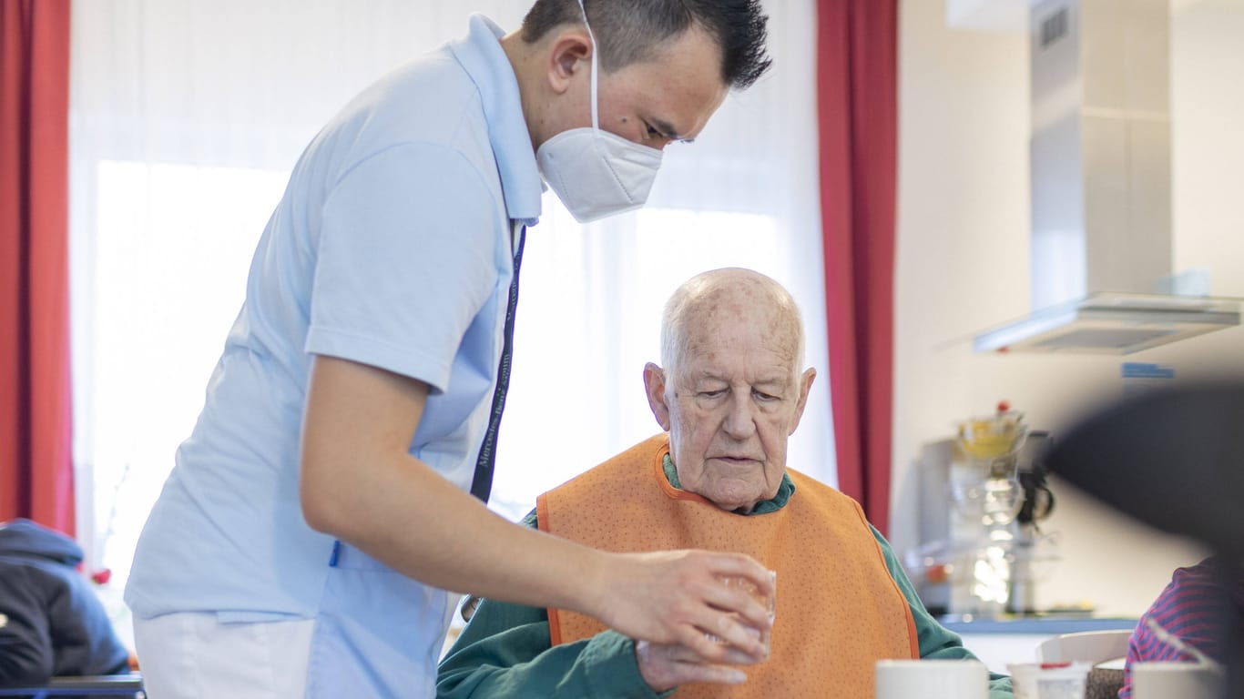 Pfleger hilft Mann beim Trinken (Symbolbild): Lauterbach ignoriere die Altenpflege, kritisieren die Patientenschützer.