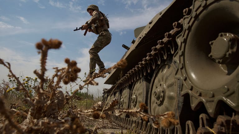 Ein ukrainischer Soldat springt von einem Panzer in der Region Cherson.