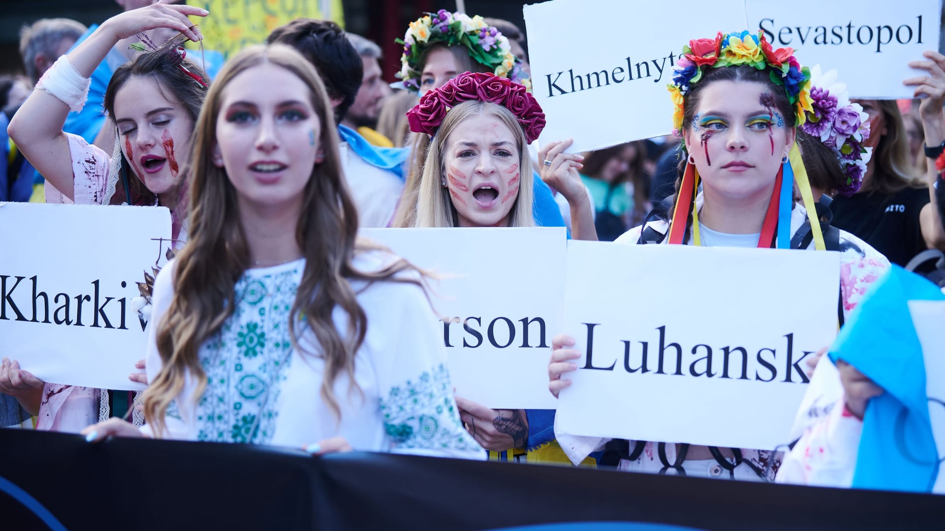 Frauen halten Plakate mit ukrainischen Städten in den Händen: 10.000 Teilnehmenden wurden zu dem Marsch erwartet. Frauen halten Plakate mit ukrainischen Städten in den Händen: 10.000 Teilnehmenden wurden zu dem Marsch erwartet.