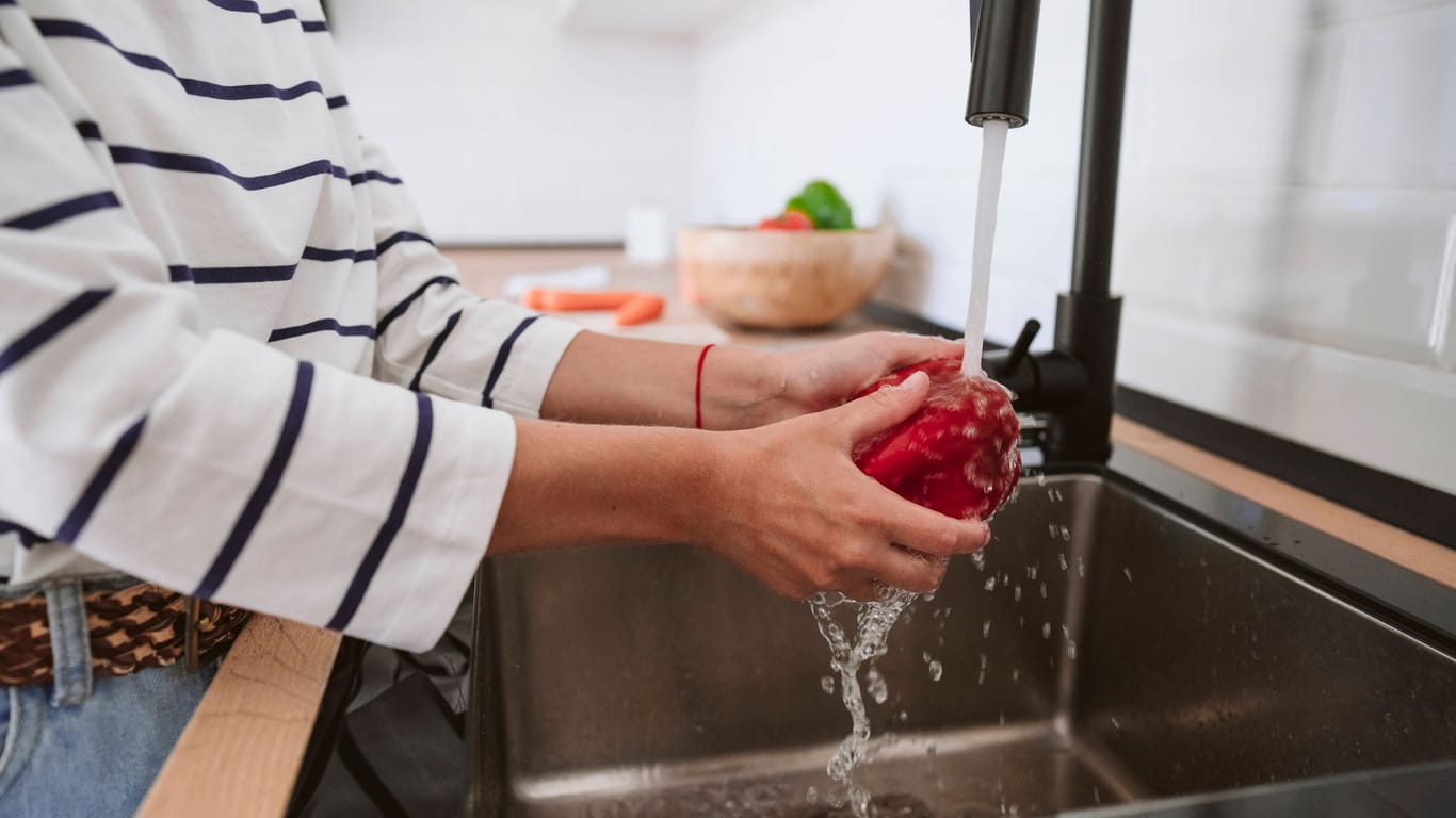 Eine Frau wäscht Gemüse (Symbolbild): 700 Haushalte bei Hannover müssen seit über einer Woche auf Trinkwasser aus der Leitung verzichten.