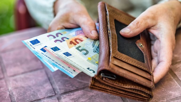 Rentnerin hält Euroscheine in der Hand (Symbolbild): Auch im Ruhestand möchte das Finanzamt etwas von Ihren Einnahmen abhaben.
