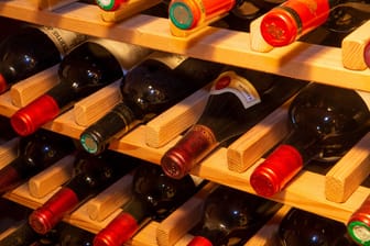 Rotweinflaschen in einem Weinregal (Symbolbild).