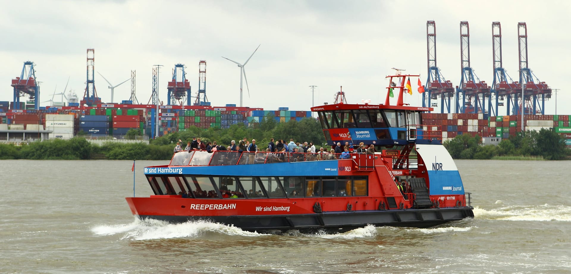 Eine Hadag-Fähre fährt durch den wolkenbehangenen Hamburger Hafen (Archivbild).