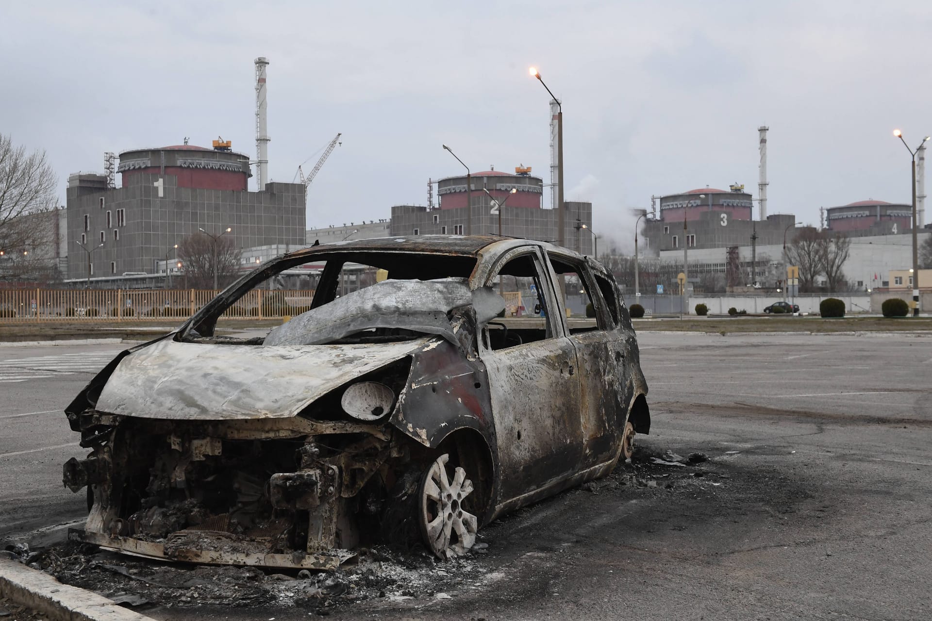 Ein ausgebranntes Auto steht vor dem Kraftwerk in Saporischschja (Archivbild): Russland soll dort Luftabwehrsysteme installiert haben.