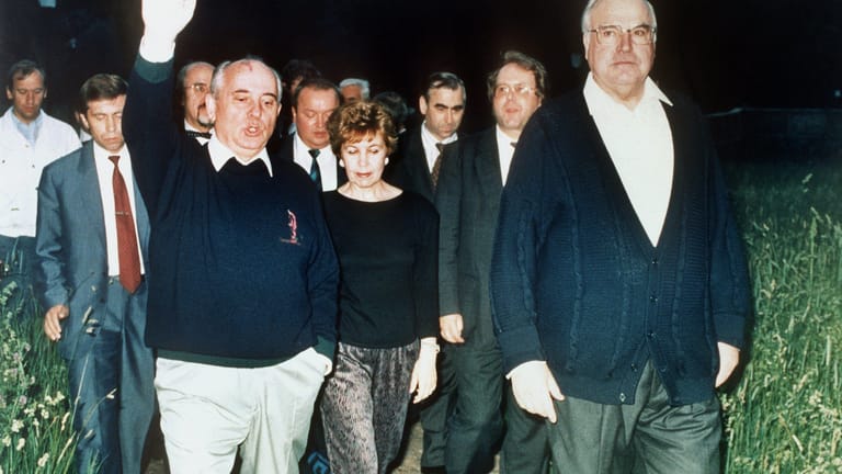 Michail Gorbatschow (l) gestikuliert während eines Spaziergangs mit Helmut Kohl (r) im Garten des Gästehauses. In der Mitte Gorbatschows Ehefrau Ehefrau Raissa.