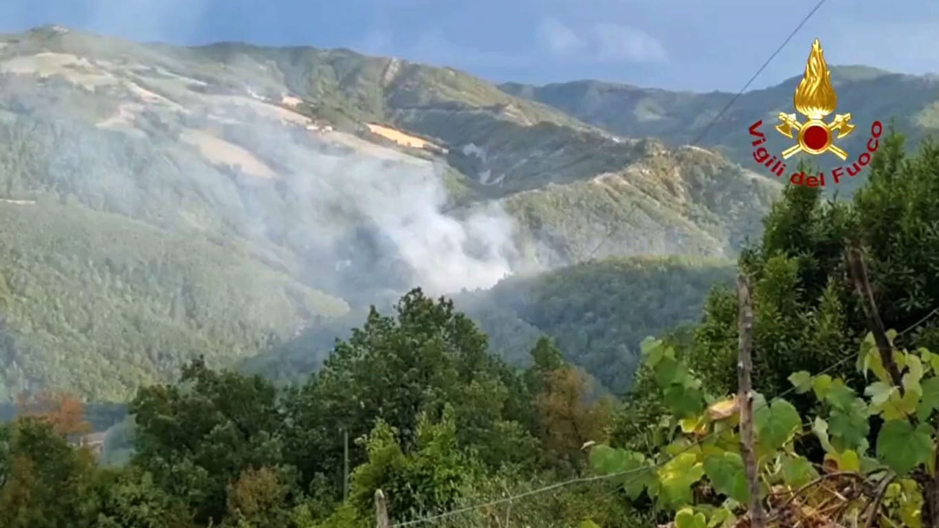Ein Videostandbild von der italienischen Feuerwehr zeigt dichten Rauch über dem Gebiet Monte Arsiccio: Einheiten der italienischen Feuerwehr kämpfen seit Montagabend gegen einen Waldbrand nahe Rimini.