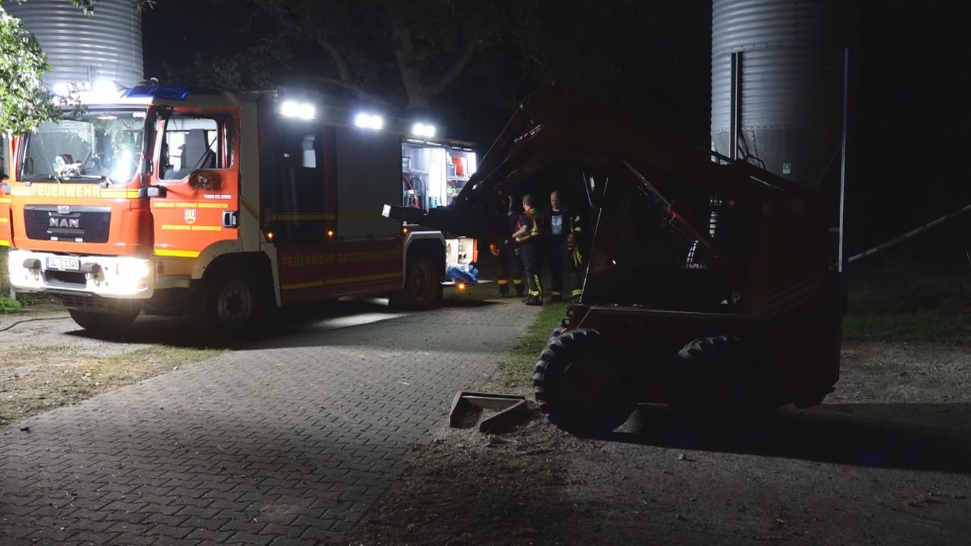 Ein kleiner Bagger und ein Einsatzfahrzeug der Feuerwehr stehen auf einem Hof: Dort kam es zu einem tödlichen Arbeitsunfall.