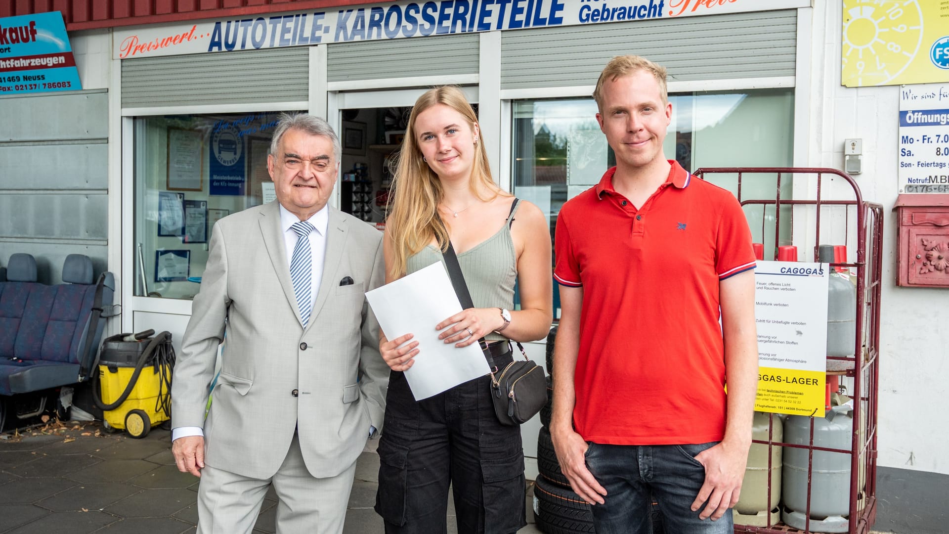 Überraschung von Herbert Reul (l.) und Daniel Schlipf: Der Innenminister hat einer glücklichen Polizeianwärterin ihre Einstellungspapiere überreicht – an einer Tankstelle. Überraschung von Herbert Reul (l.) und Daniel Schlipf: Der Innenminister hat einer glücklichen Polizeianwärterin ihre Einstellungspapiere überreicht – an einer Tankstelle.
