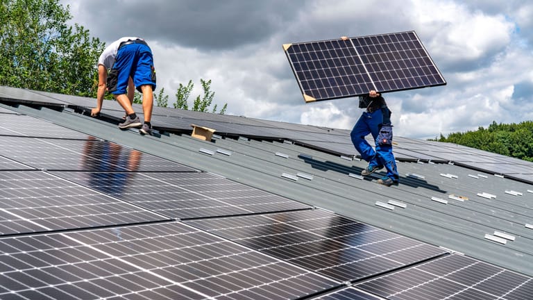 Montage von Solarmodulen auf dem Dach einer Scheune in Nordrhein-Westphalen (Archiv): Im ersten Halbjahr 2022 wurden 157.566 Anlagen installiert.