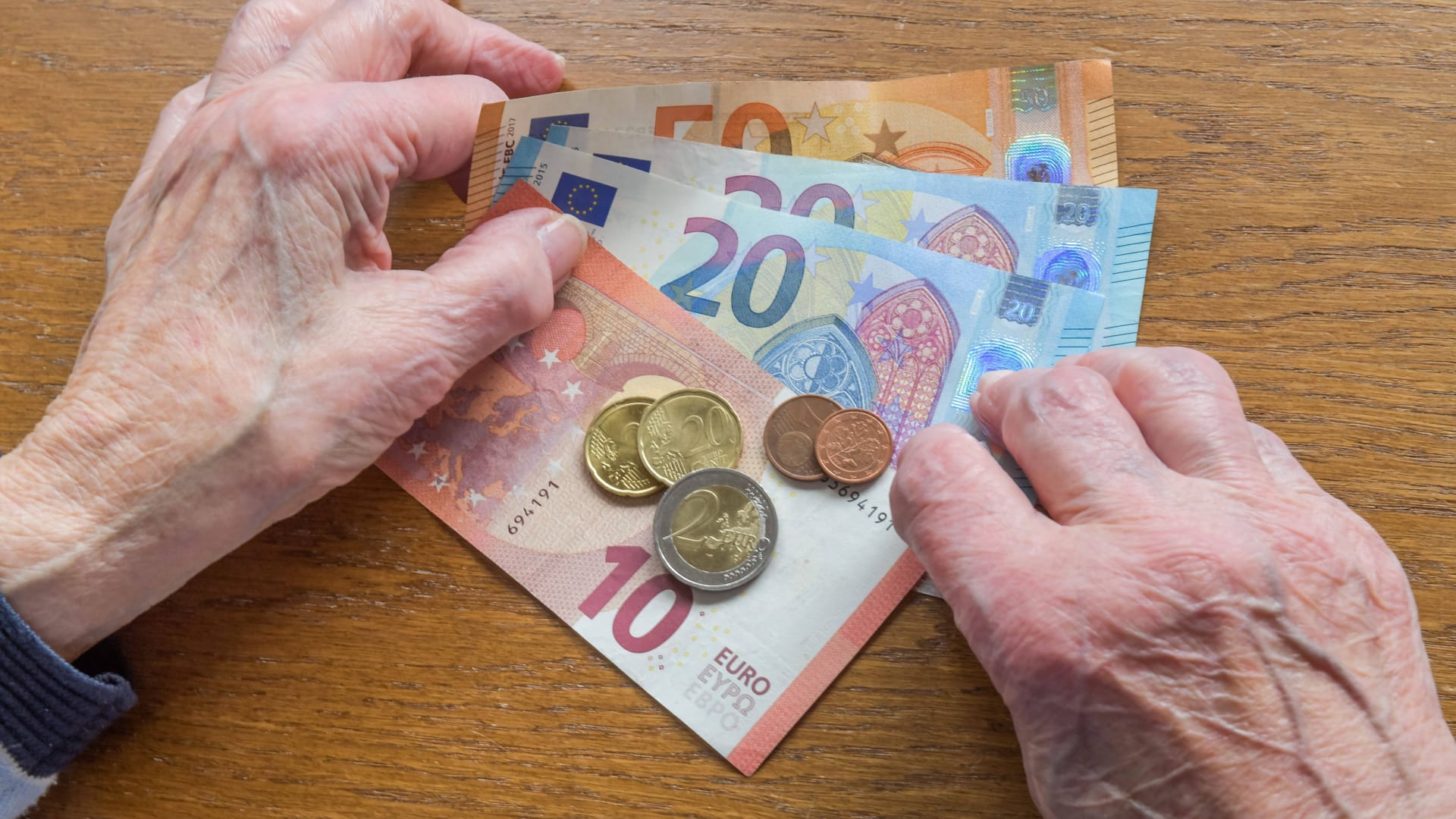 Eine Seniorin zählt Geld ab: Der Rentenkasse droht der Kollaps.