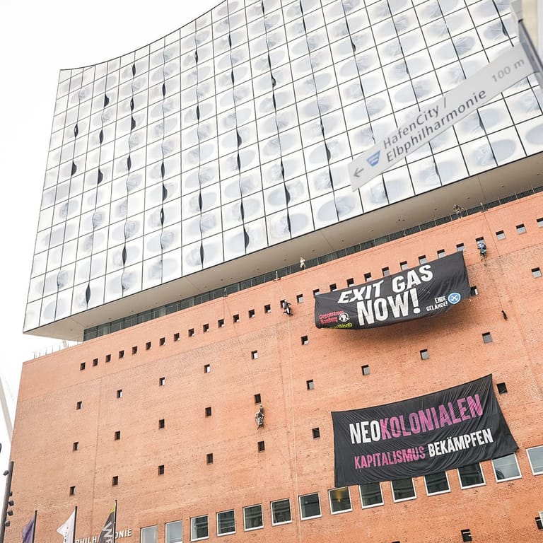 Aktivisten seilen sich von der Elbphilharmonie ab und entrollen zwei Banner: In dieser Woche soll es in Hamburg im Rahmen eines Protestcamps zu mehreren Aktionen kommen.