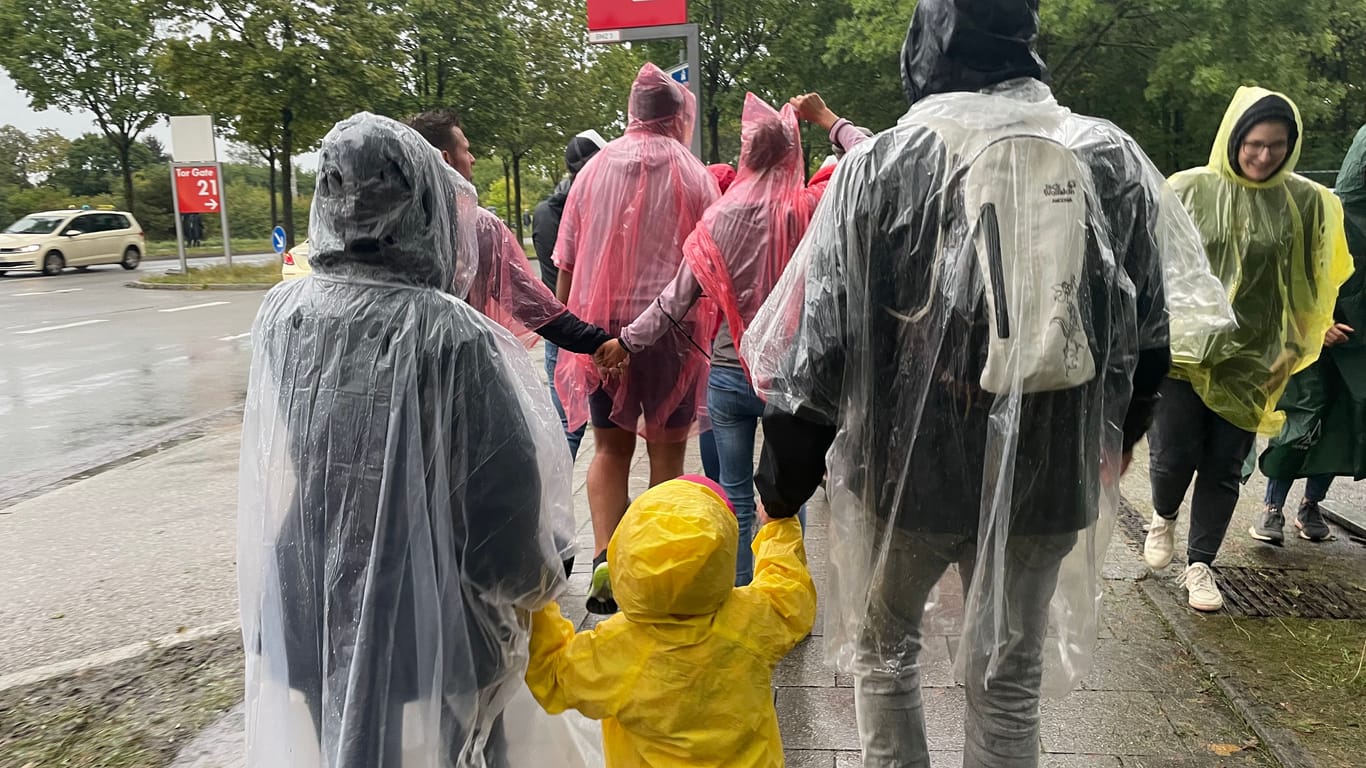 Regenschirme verboten: Zahlreiche Fans in Regen-Klamotten haben sich in Ponchos gerettet.