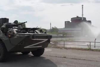 Ein russisches Panzerfahrzeug fährt am AKW Saporischschja vorbei.
