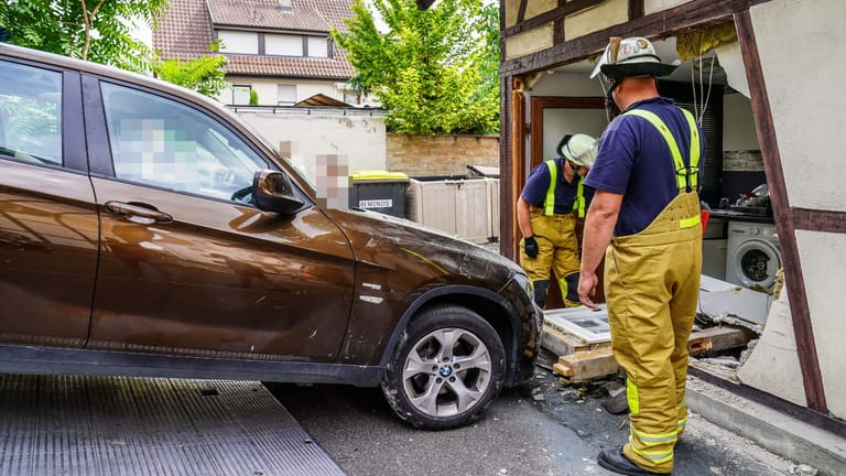 Auto vor der durchbrochenen Hauswand: Die Feuerwehr zog den BMW wieder aus dem Fachwerkhaus heraus.