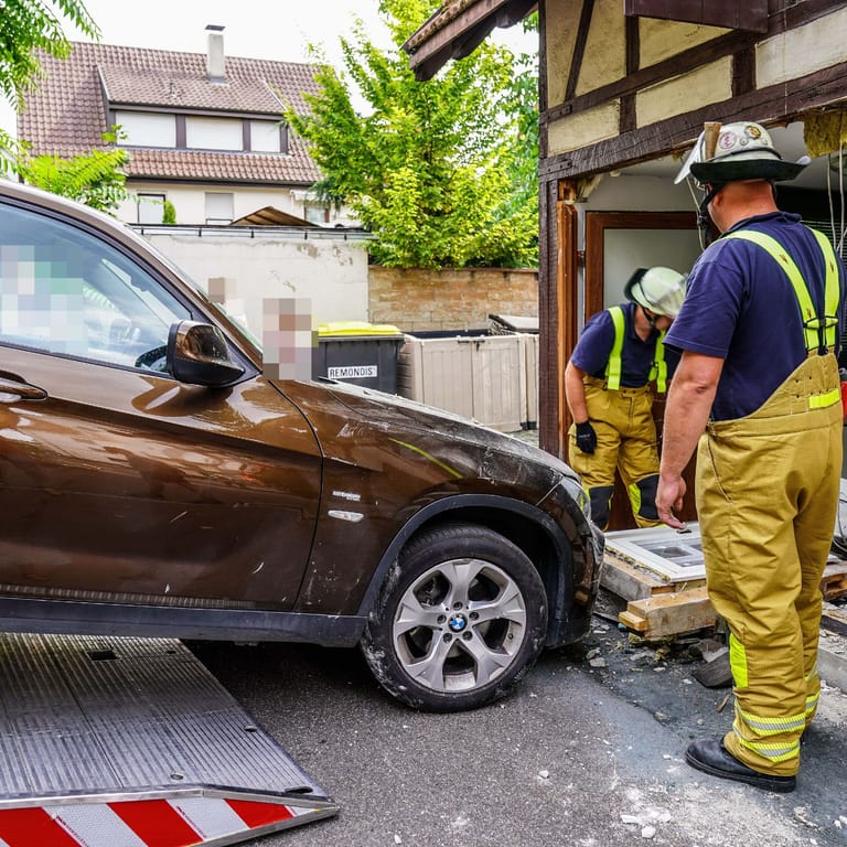 Auto vor der durchbrochenen Hauswand: Die Feuerwehr zog den BMW wieder aus dem Fachwerkhaus heraus.