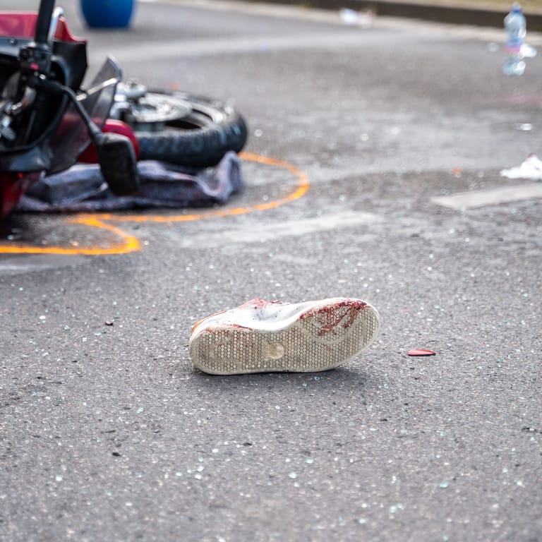 Der Schuh eines lebensgefährlich verletzten Motorradfahrers liegt auf der Straße in Nürnberg: Ein besonders dreister Gaffer behinderte die Arbeit der Polizei.